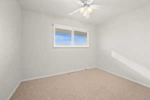 Carpeted empty room with baseboards and ceiling fan