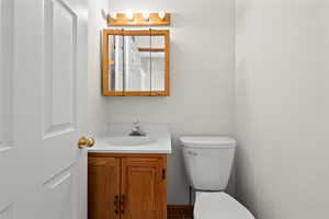 Half bathroom featuring vanity and toilet