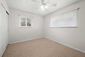 Unfurnished bedroom with a closet, carpet, and a ceiling fan