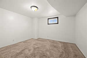 Carpeted empty room with a textured ceiling and baseboards