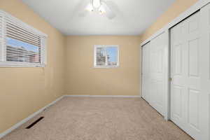 Unfurnished bedroom featuring a closet, ceiling fan, and light colored carpet