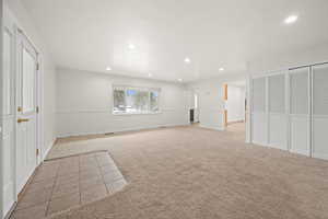 Unfurnished bedroom featuring light colored carpet, a closet, recessed lighting, light tile patterned floors, and a textured ceiling
