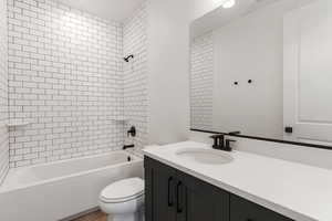 Bathroom featuring vanity, tub / shower combination, and wood finished floors