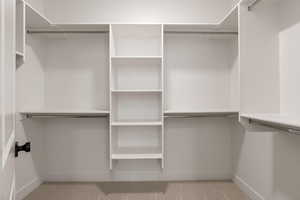 Walk in closet featuring light carpet