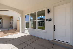 View of exterior entry with a patio and stucco siding