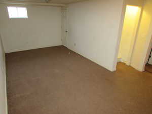 Basement featuring carpet and baseboards