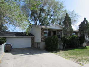 Ranch-style home with driveway, a front yard, and brick siding