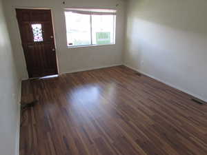 Entryway featuring baseboards and dark wood-type flooring