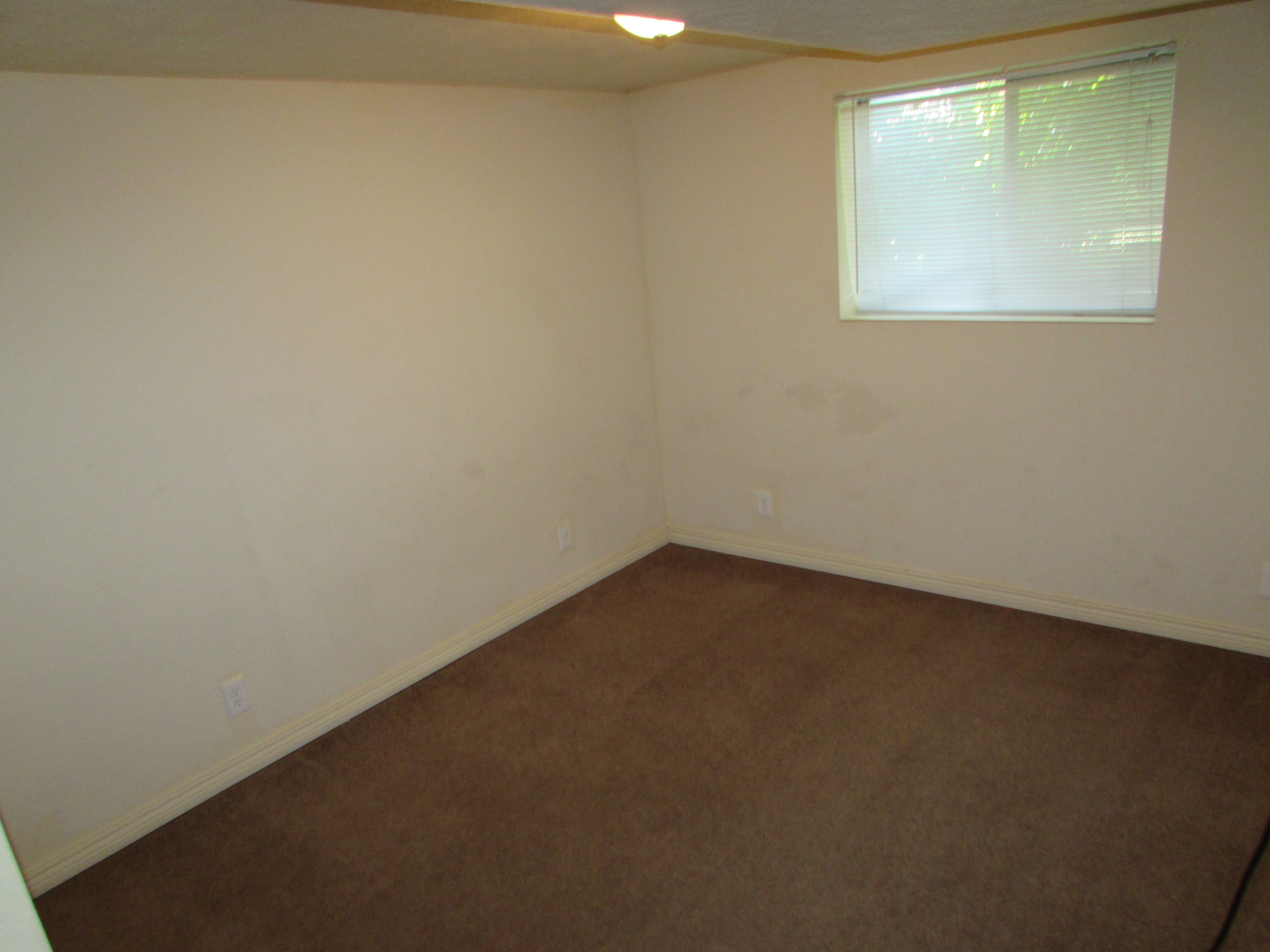 Empty room featuring carpet flooring and baseboards