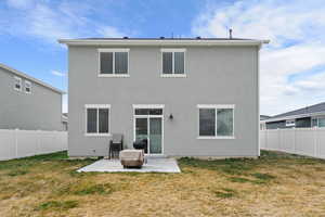 Back of property featuring a fenced backyard, a patio area, and stucco siding