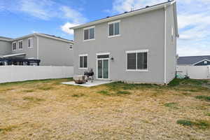 Back of house featuring a patio area, a fenced backyard, and stucco siding