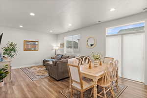 Dining room featuring light wood-style floors, recessed lighting, and a textured ceiling