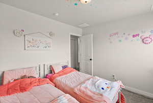 Bedroom featuring carpet floors and a textured ceiling
