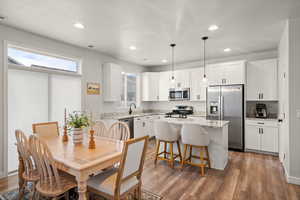 Dining area featuring light wood-type flooring, recessed lighting, and a textured ceiling