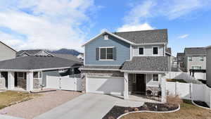 View of front of property with a gate, stone siding, driveway, a garage, and a shingled roof