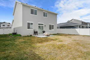 Rear view of house with a patio, a fenced backyard, a gate, and stucco siding