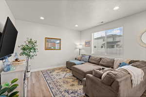 Living area with recessed lighting, light wood-type flooring, and a textured ceiling