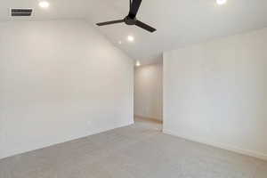 Empty room with carpet, ceiling fan, vaulted ceiling, and recessed lighting
