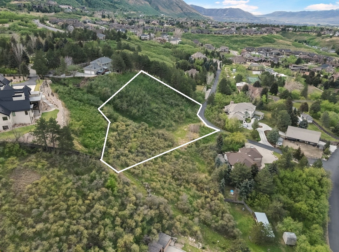 Aerial view of residential area featuring property parcel outlined and mountains