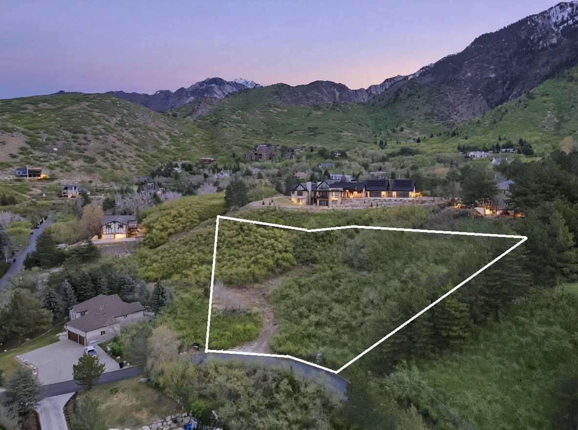 Aerial overview of property's location with a mountain backdrop and property parcel outlined