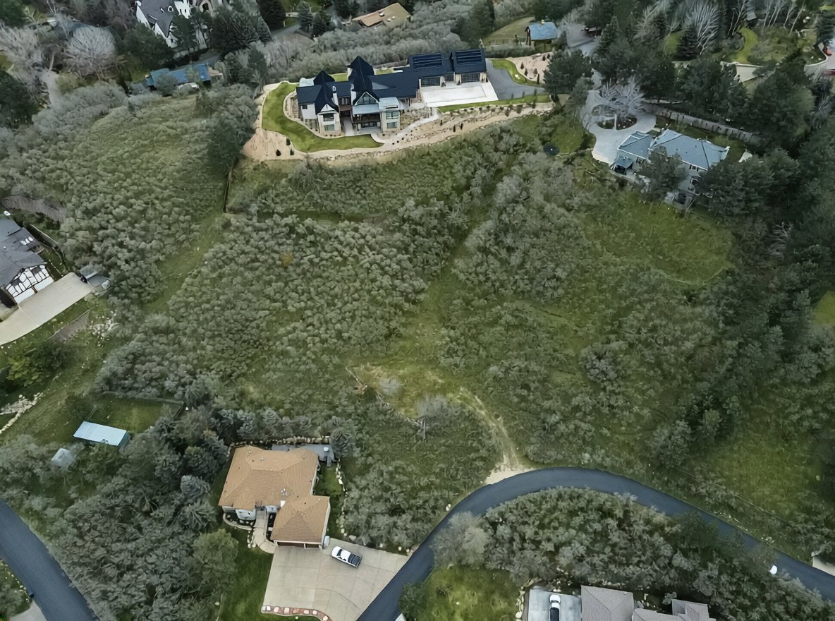 Aerial view of property and surrounding area featuring nearby suburban area