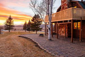View of jungle gym featuring a patio, a deck with mountain view, and a yard