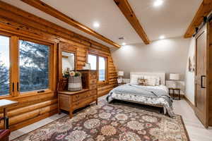 Bedroom featuring log walls, a barn door, recessed lighting, and beamed ceiling