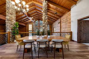 Dining space with hardwood / wood-style flooring, a chandelier, and a high wooden beamed ceiling