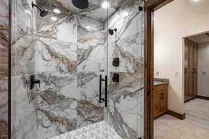 Full bathroom with a marble finish shower and vanity