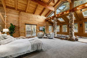 Bedroom featuring a high wooden beamed ceiling, access to exterior, and carpet floors