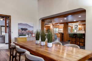 Dining room featuring dark wood-style floors, rustic walls, recessed lighting, and arched walkways