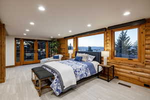 Bedroom featuring log walls, access to exterior, a mountain view, and recessed lighting