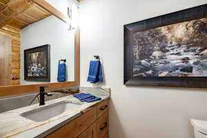Half bathroom featuring vanity and wood ceiling