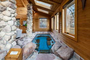View of pool with a hot tub and a skylight
