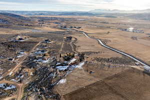 Aerial view of property and surrounding area featuring mountains and rural landscape