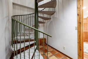 Stairs featuring baseboards and tile patterned floors