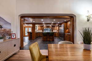 Dining room featuring recessed lighting, arched walkways, and dark wood finished floors