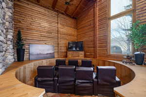 Living room featuring rustic walls and a high wooden beamed ceiling