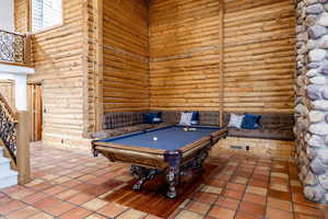Recreation room featuring log walls and billiards