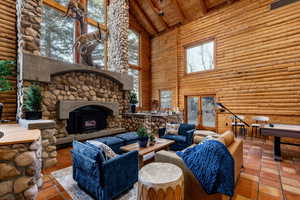 Living room with log walls, a high wood beamed ceiling, and french doors