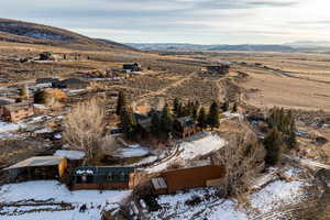 Aerial overview of property's location featuring a mountainous background and nearby suburban area