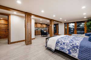 Bedroom featuring recessed lighting, access to exterior, light wood-style flooring, and rustic walls