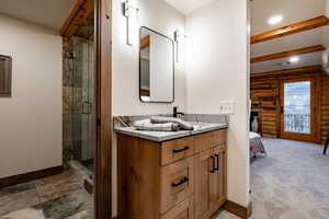 Full bath with rustic walls, vanity, a shower stall, ensuite bath, and recessed lighting