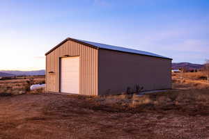 Detached garage with a mountain view and a view of rural / pastoral area
