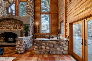 Interior space with french doors, a high ceiling, and log walls