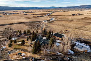 Aerial view of property and surrounding area featuring mountains and rural landscape