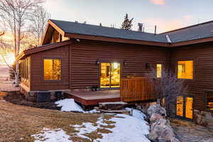 Snow covered property featuring roof with shingles and a wooden deck