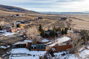 Snowy aerial view featuring a mountain view, a residential view, and a view of rural / pastoral area