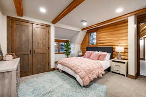 Bedroom featuring log walls, a closet, and light colored carpet