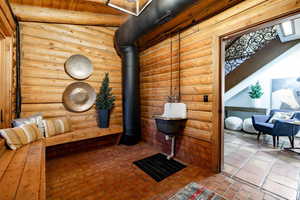 Bathroom featuring log walls and beamed ceiling